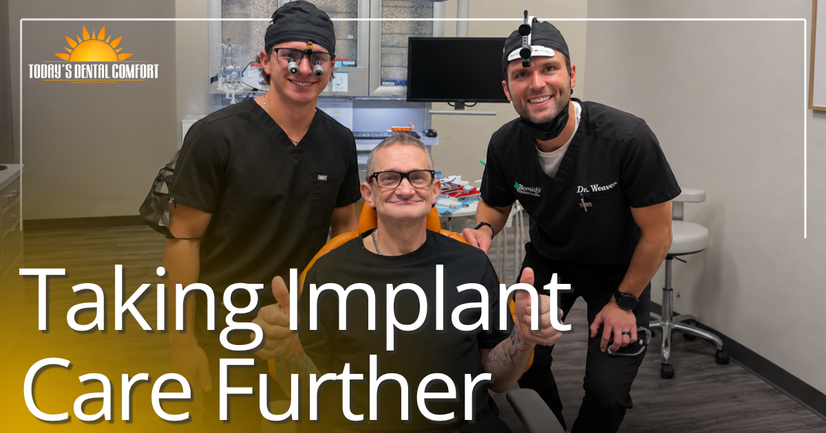 Taking Implant Care Further two doctors smiling with patient in dental chair